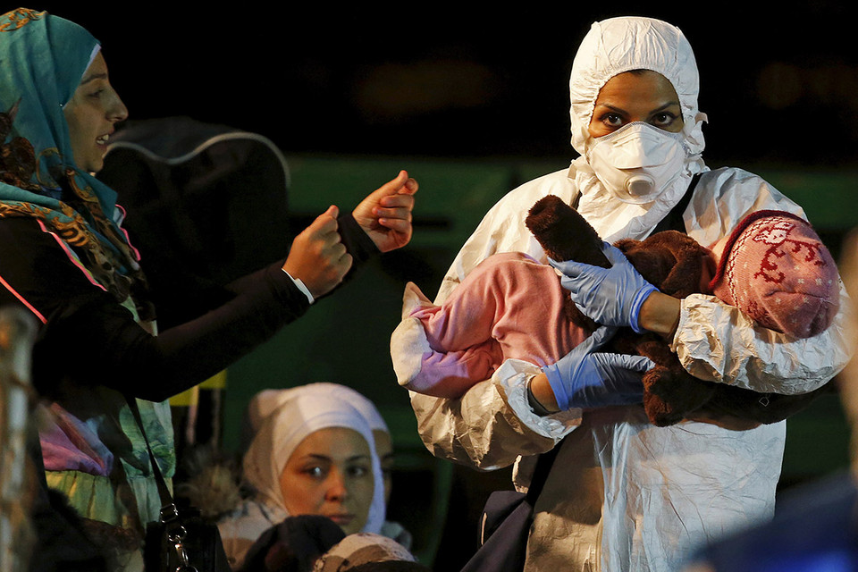 Nhân viên cứu hộ bế một em bé khỏi tàu chở 98 người tị nạn ở cảng Sicilian vào ngày 19/4/2015. (Nguồn: Reuters)