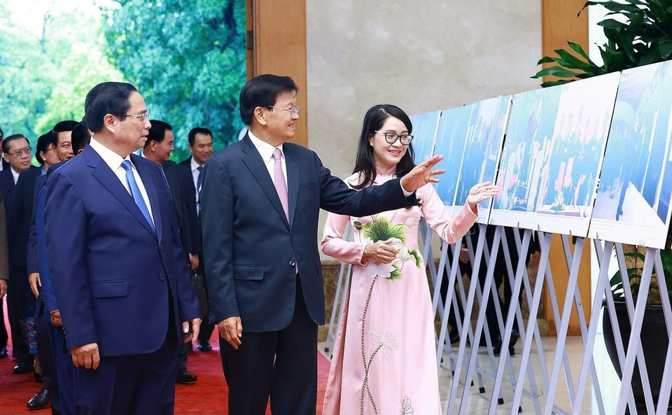 Thủ tướng Phạm Minh Chính và Tổng Bí thư, Chủ tịch nước Lào Thongloun Sisoulith xem trưng bày những hình ảnh tiêu biểu về quan hệ Việt-Lào, do TTXVN thực hiện. (Ảnh: Dương Giang/TTXVN)