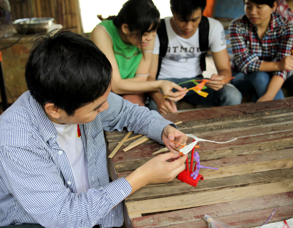 Bạn Linh (sinh viên trường Đại học Thủy Lợi) thích thú khi xếp chồng các con chuồn chuồn lên nhau để thử độ thăng bằng. (Ảnh: Doãn Đức/Vietnam+)
