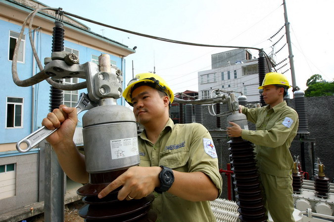 Lắp đặt thiết bị đầu cốt sứ máy biến áp cấp điện tại Trạm biến áp 220kV Thành Công. (Ảnh: Huy Hùng/TTXVN)