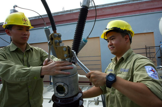 Lắp đặt thiết bị đầu cốt sứ máy biến áp cấp điện tại Trạm biến áp 220kV Thành Công. (Ảnh: Huy Hùng/TTXVN)