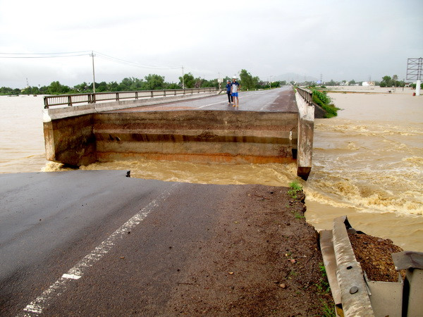 Lũ lớn quấn trôi mố cầu Bình Định, dài khoảng 15m trên Quốc lộ 1A, gây ách tắc hoàn toàn giao thông trên tuyến giao thông huyết mạch này. (Ảnh: Viết Ý/TTXVN)