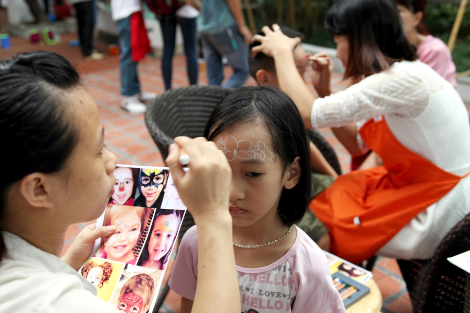 Đến với lễ hội, các bé sẽ được 'săm' những hình độc đáo nhất lên trán. (Ảnh: Doãn Đức/Vietnam+)