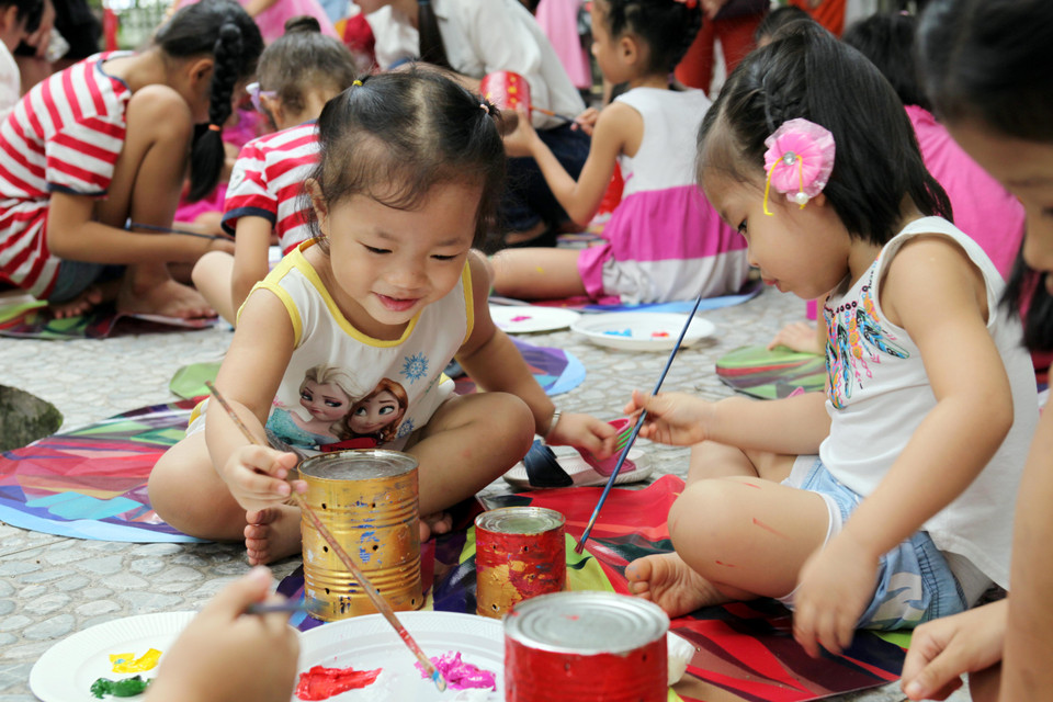 Bé Lan (Giảng Võ, Hà Nội) tỏ ra thích thú với 'công việc' của mình. (Ảnh: Doãn Đức/Vietnam+)