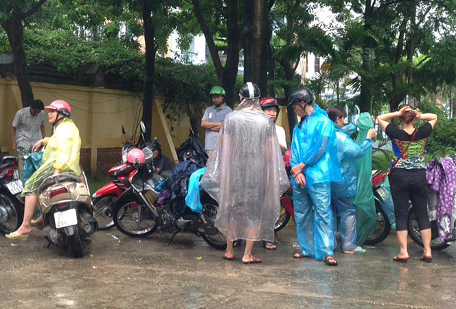 Tại điểm thi trung tâm giáo dục thường xuyên Thanh Trì (Phan Trọng Tuệ, Thanh Trì, Hà Nội), bất chấp cơn mưa nặng hạt, hàng chục phụ huynh và thí sinh đã có mặt từ rất sớm. (Ảnh: Sơn Bách/Vietnam+)