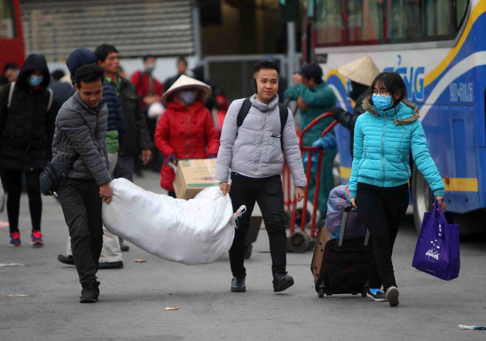 Người dân xuống xe khách với lỉnh kỉnh đồ đạc tại bến xe Giáp Bát. (Ảnh: Thanh Tùng/TTXVN)