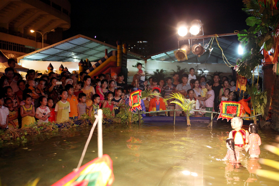 Tiết mục múa rối nước thu hút khá đông các du khách tham quan đặc biệt là các em nhỏ. (Ảnh: Doãn Đức/Vietnam+)