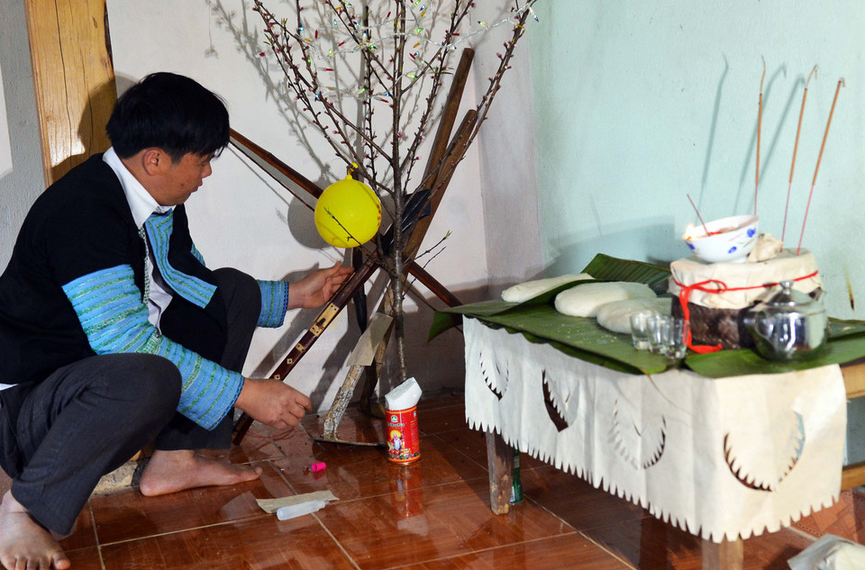 Góc nhà được trang trí một cành đào, dụng cụ sản xuất, săn bắn được được niêm phong, không sử dụng trong ba ngày ăn tết. (Ảnh: Thanh Hà/TTXVN) 