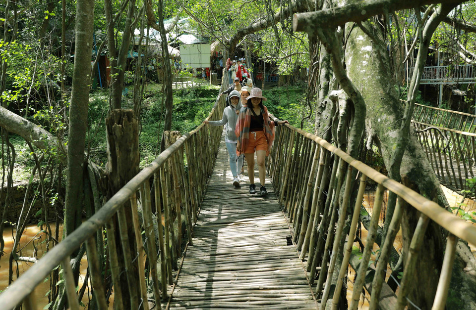 Du khách tham quan điểm du lịch cầu treo Buôn Đôn. (Ảnh: Vũ Sinh/TTXVN)