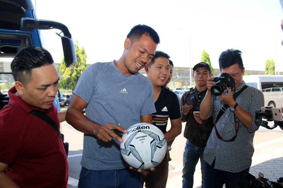 Một người hâm mộ chuẩn bị sẵn trái bóng để xin chữ ký các thành viên đội tuyển Việt Nam. (Ảnh: Phạm Kiên/Vietnam+)