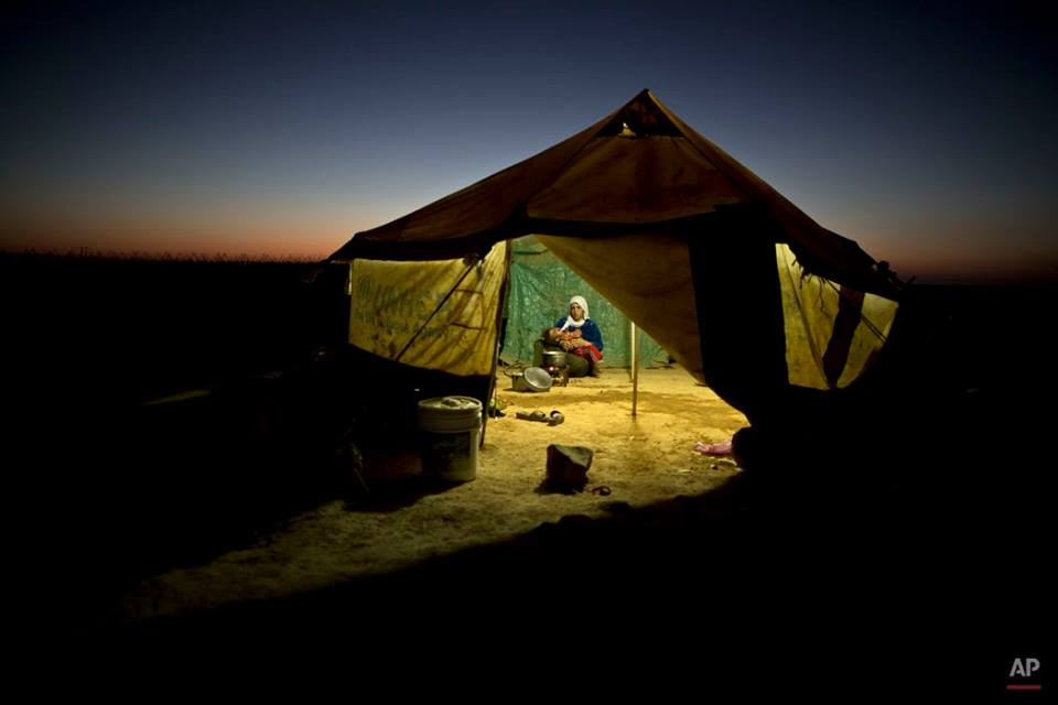 Một người tị nạn Syria bế con gái ở lều tạm gần biên giới Syria. (Nguồn: AP)