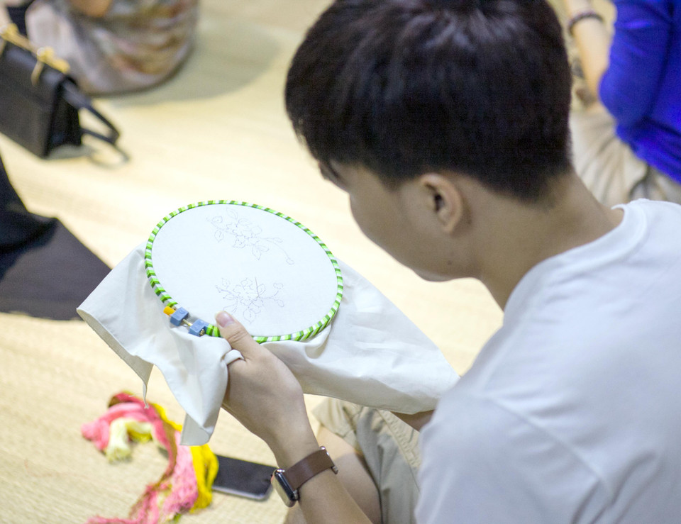 ‘Phái mạnh’ cũng chăm chú thực hành kĩ thuật thêu cung đình. (Ảnh: Doãn Đức/Vietnam+)