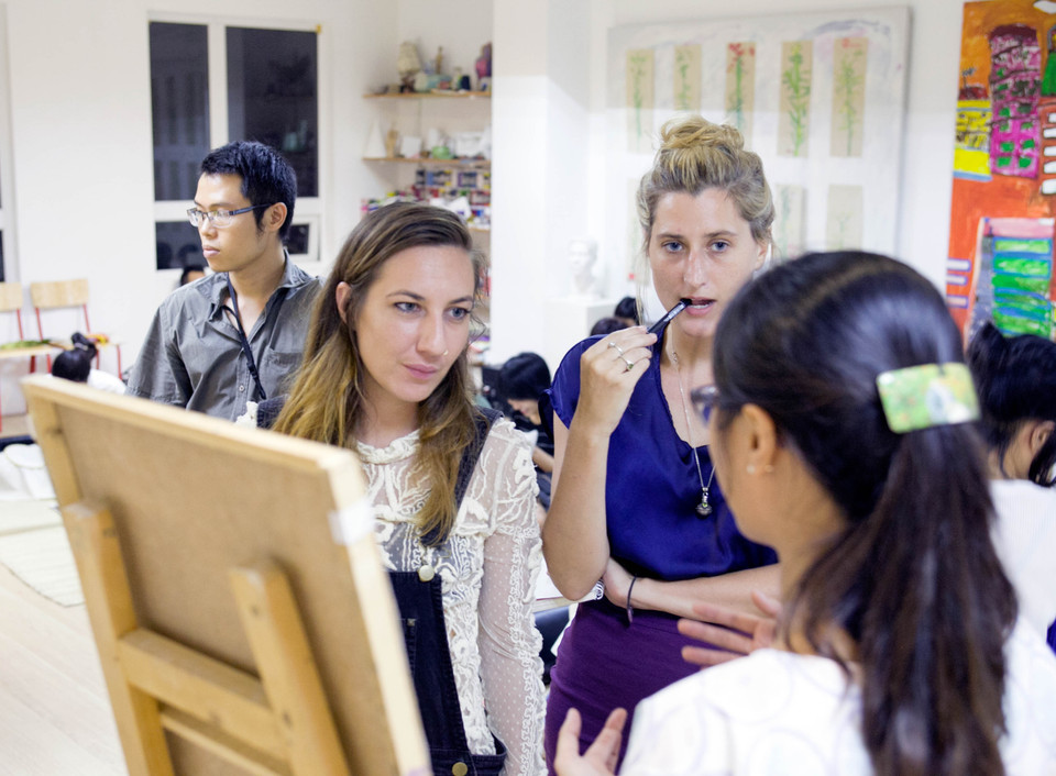 Các bạn trẻ cùng nhau chia sẻ các kĩ thuật thêu. (Ảnh: Doãn Đức/Vietnam+)