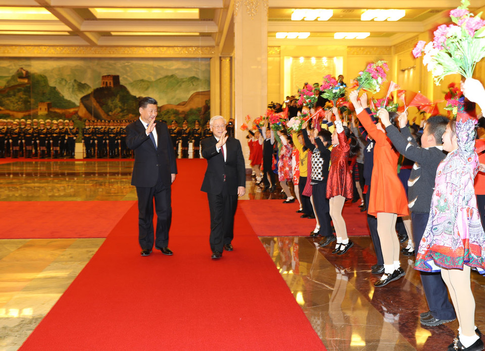 Tổng Bí thư Nguyễn Phú Trọng và Tổng Bí thư, Chủ tịch nước Trung Quốc Tập Cận Bình vẫy chào các cháu thiếu nhi tại lễ đón. (Ảnh: Trí Dũng/TTXVN)