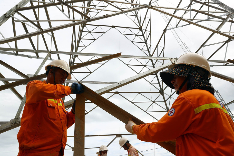 Công nhân Truyền tải điện Hà Tĩnh thi công lắp dựng cột tại vị trí 40 địa bàn huyện Kỳ Anh (Hà Tĩnh). (Ảnh: Huy Hùng/TTXVN)