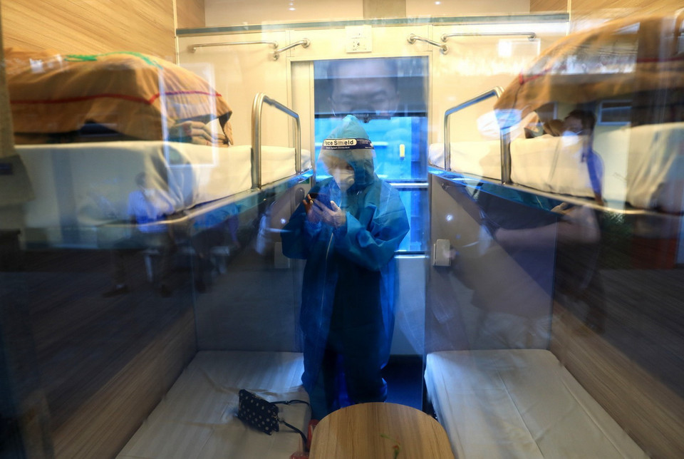 Một số hành khách cẩn thận mặc đồ bảo hộ phòng dịch khi lên tàu. (Ảnh: Thành Đạt/TTXVN)