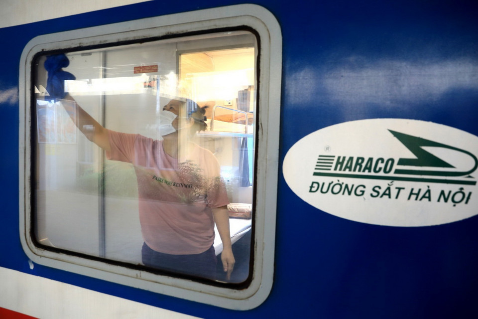 Nhân viên Ga Hà Nội lau dọn toa tàu sau nhiều ngày phơi nắng phơi mưa. (Ảnh: Thành Đạt/TTXVN)