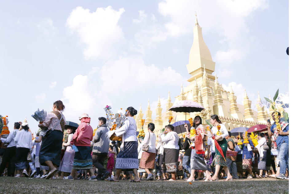 Người dân Lào trong trang phục truyền thống trong lễ rước Pasatpheung (Rước tháp), một trong những lễ chính mở đầu cho phần lễ hàng năm trong lễ hội Thatluang. (Ảnh: Phạm Kiên-Bá Thành/TTXVN)