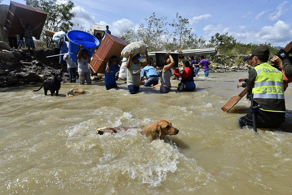 Người Colombia xuất cảnh khỏi Venezuela mang theo các vật dụng cá nhân vượt sông Tachira. (nguồn: AFP)