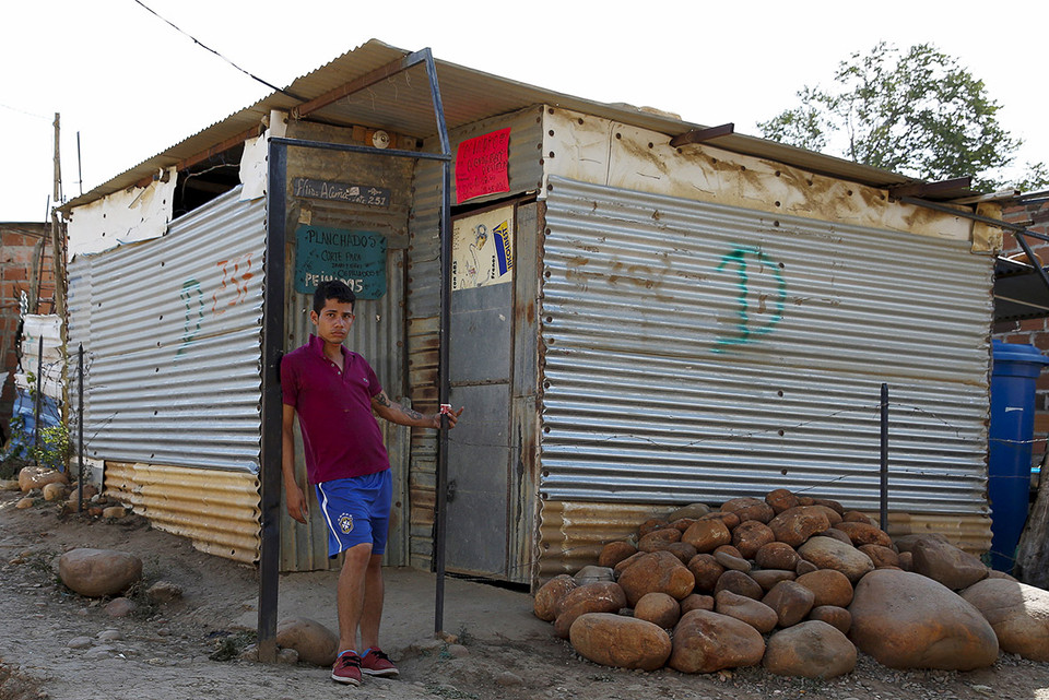 Một thanh niên đứng trước cửa nhà sau khi nhận được thư sẽ phá hủy khu vực này từ chính quyền địa phương. (Nguồn: Reuters)