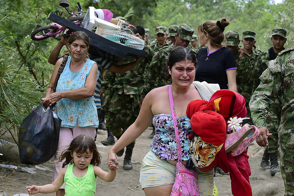 Một người phụ nữ Colombia vừa khóc vừa dẫn theo con gái vượt qua biên giới Venezuela. (nguồn: AFP)