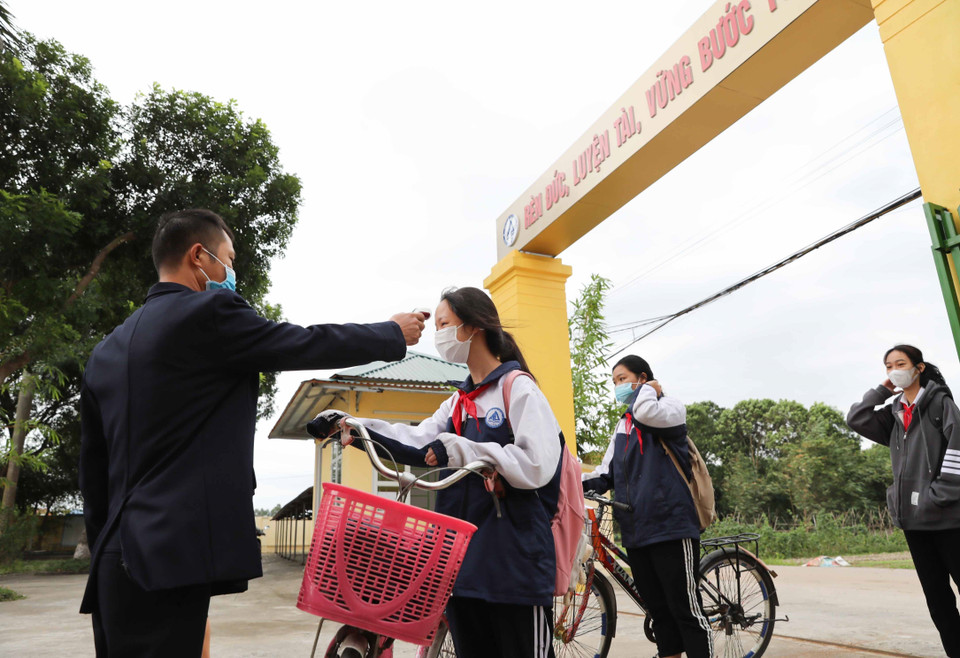 Các trường thực hiện nghiêm việc đo thân nhiệt, sát khuẩn tay cho học sinh khi tới trường. (Ảnh: Thanh Tùng/TTXVN)
