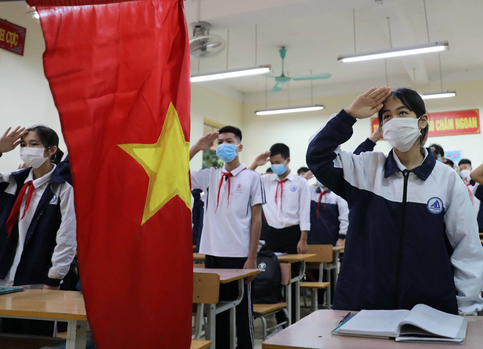 Học sinh lớp 9 trường trung học cơ sở Mai Đình, huyện Sóc Sơn chào cờ, hát Quốc ca tại lớp. (Ảnh: Thanh Tùng/TTXVN)