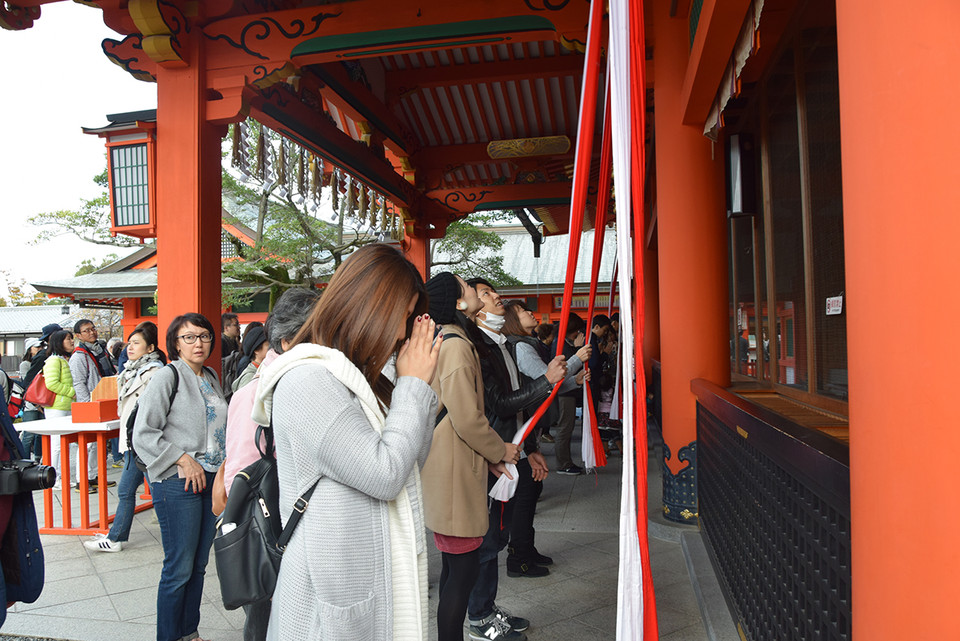 Du khách thực hiện nghi thức rung chuông khi cầu nguyện tại đền chính của ngôi đền Fushhimi Inari. (Ảnh: Nguyễn Tuyến​/Vietnam+)