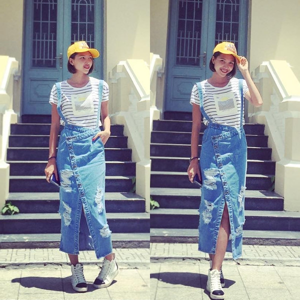 Siêu mẫu Minh Triệu chọn áo phông kẻ cùng chân váy yếm lạ mắt, kết hợp với giày sneakers cao cổ xuống phố ngày nắng đẹp.