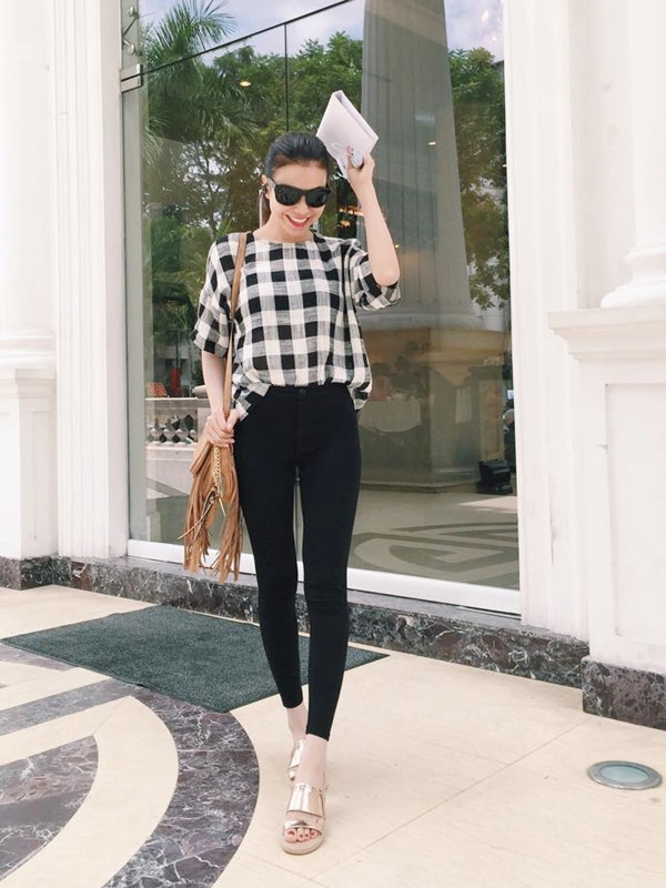 Trà Ngọc Hằng chọn áo phông kẻ gingham phối cùng quần ôm cạp cao khoe đôi chân dài. Người đẹp 'mix' trang phục cùng dép quai ngang ánh kim và túi tua rua mang cảm hứng du mục.