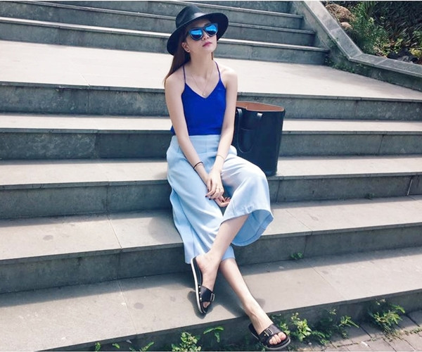 Thiều Bảo Trang chọn trang phục phóng khoáng để tận hưởng kỳ nghỉ cùng gia đình của mình. Nữ ca sỹ 'mix' hài hòa áo hai dây xanh cobalt cùng quần ống rộng (culottes) xanh phấn và kính mắt trang gương vừa tránh nắng, vừa tô thêm vẻ sành điệu.
