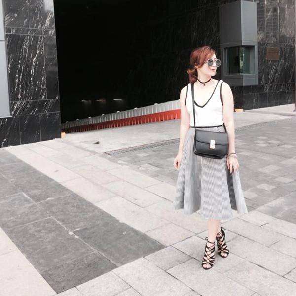 Yến Nhi diện đầm không tay dáng chữ A cùng túi đeo chéo và sandals đan dây bắt mắt.