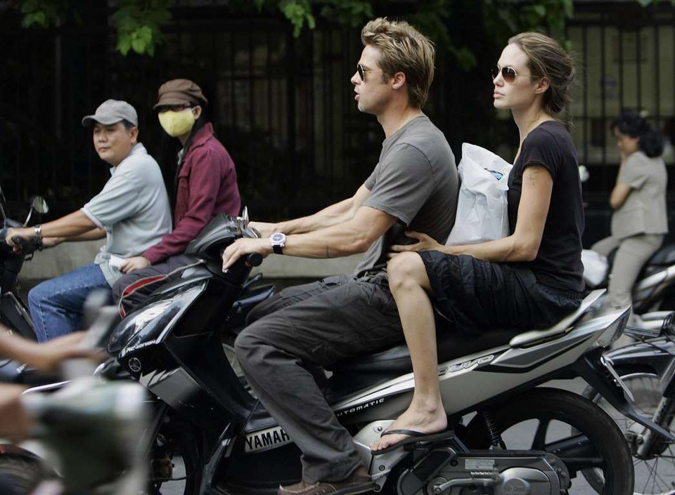Brad Pitt cùng vợ Angelina Jolie lái chiếc Yamaha Nouvo trong chuyến thăm Việt Nam. (Nguồn: AFP)