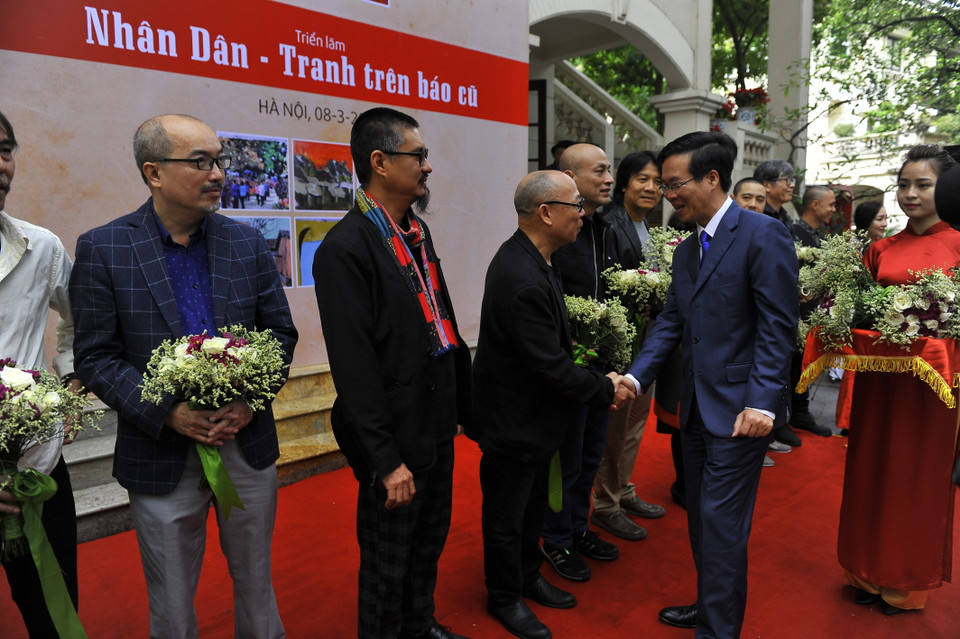 Ông Võ Văn Thưởng (Ủy viên Bộ Chính trị, Bí thư Trung ương Đảng Trưởng Ban Tuyên giáo Trung ương) tặng hoa cho họa sĩ tham dự triển lãm. (Ảnh: Ngọc Tùng/Vietnam+)