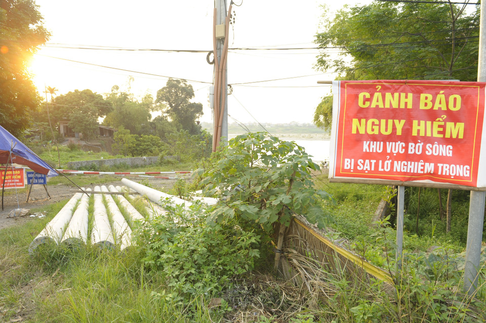 Chính quyền làm biển cảnh báo nguy hiểm ở khu vực sạt lở tại thôn Trung Hà, xã Thái Hòa (huyện Ba Vì). (Ảnh: Mạnh Khánh/TTXVN)