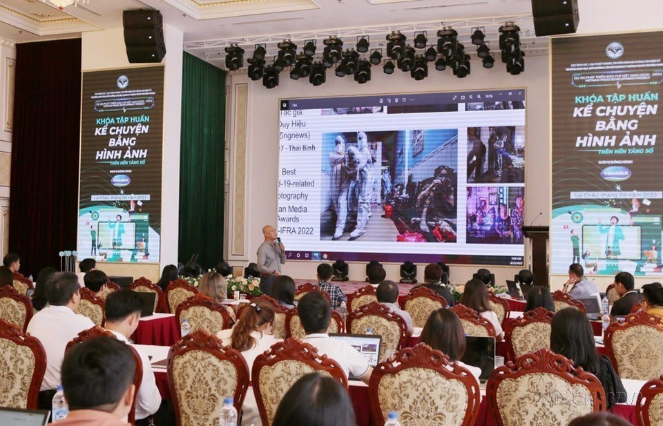 Nhiếp ảnh gia Nguyễn Á giới thiệu, kể chuyện về các tác phẩm ảnh xuất sắc cho học viên tại lớp tập huấn “Kể chuyện bằng hình ảnh trên các loại hình truyền thông.” (Ảnh: Quý Trung/TTXVN)