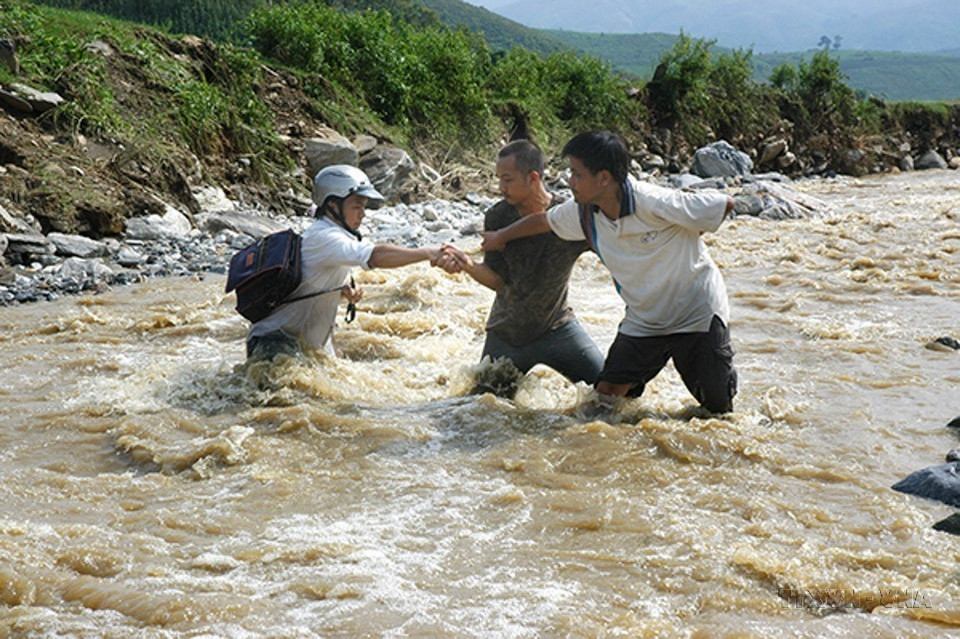 Phóng viên Xuân Trường (Thông tấn xã Việt Nam) cùng đồng nghiệp đi vào tâm lũ Tùng Chỉn, Bát Xát (Lào Cai), năm 2008. (Ảnh: TTXVN)