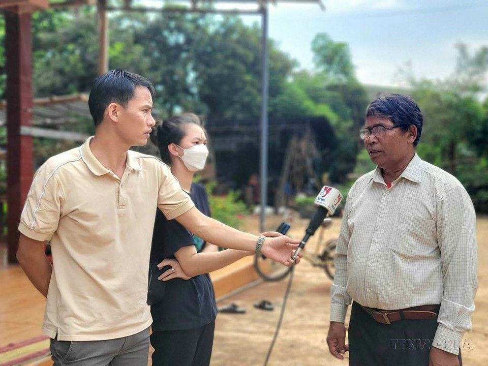 Phóng viên Cơ quan thường trú Thông tấn xã Việt Nam tại Gia Lai Trần Quang Thái phỏng vấn mục sư Ae Smit (Y Djan EBan), người có uy tín tại xã Ea Ktur, huyện Cư Kuin (tỉnh Đắk Lắk), tháng 6/2023. (Ảnh: TTXVN)