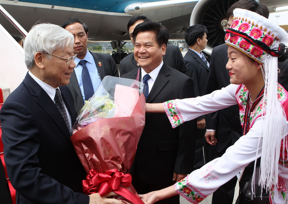 Thiếu nữ dân tộc tặng hoa chúc mừng Tổng Bí thư Nguyễn Phú Trọng tại Sân bay Quốc tế Trường Thuỷ, thành phố Côn Minh. (Ảnh: Trí Dũng/TTXVN) 