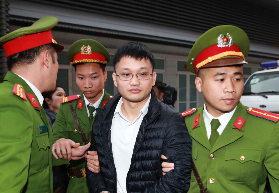 Cảnh sát dẫn giải các bị cáo đến phiên tòa xét xử. (Ảnh: Doãn Tấn/TTXVN)