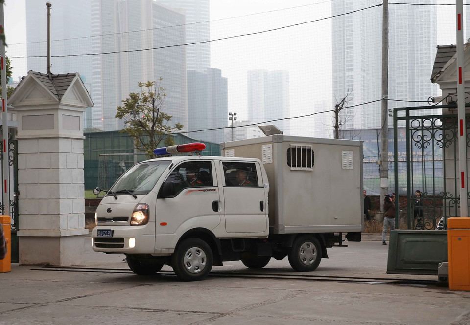 Cảnh sát dẫn giải các bị cáo đến phiên tòa xét xử. (Ảnh: Doãn Tấn/TTXVN)