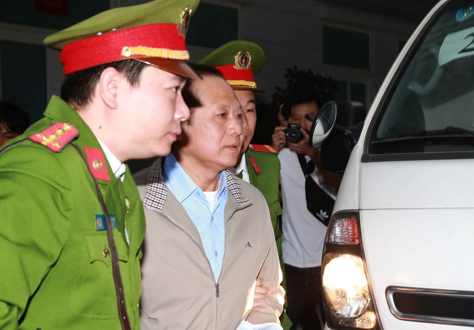 Cảnh sát dẫn giải bị cáo Trương Minh Tuấn (sinh năm 1960, cựu Bộ trưởng Bộ Thông tin và Truyền thông) đến tòa. (Ảnh: Văn Điệp/TTXVN)