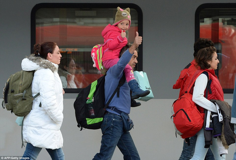 Hai bố con ra hiệu 'hạnh phúc' khi tới Munich sau hành trình đầy khó khăn. (nguồn: Dailymail)