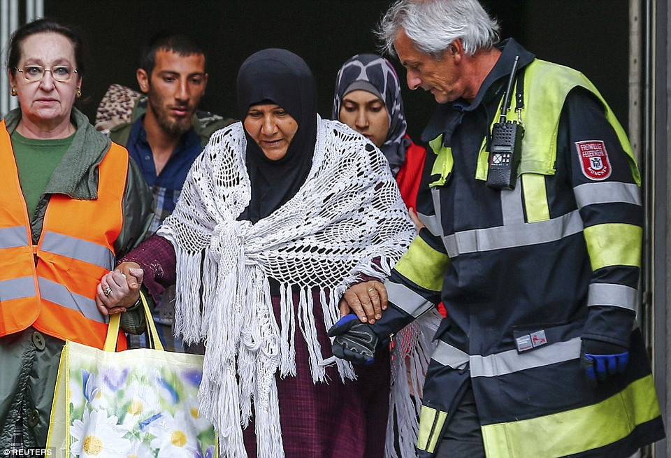 Ở Munich, các tình nguyện viên Đức giúp một bà cụ. (Nguồn: Dailymail)