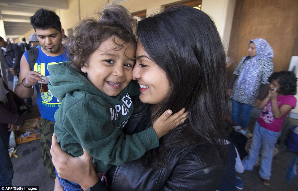 Tình nguyện viên người Áo Torma ôm em bé nhập cư 3 tuổi Diana ở nhà ga Westbahnhof. (Nguồn: Dailymail)