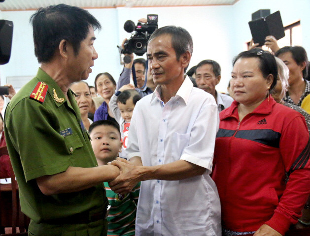 Ông Phạm Thật, Phó Giám đốc công an Bình Thuận, chúc mừng ông Huỳnh Văn Nén đã được minh oan. (Ảnh: Nguyễn Thanh/TTXVN)