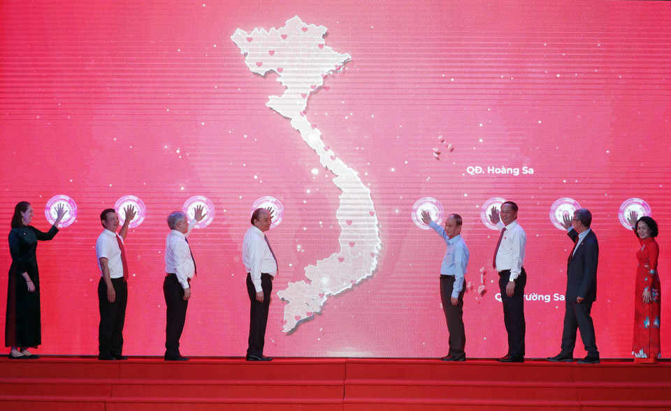 Chủ tịch nước Nguyễn Xuân Phúc cùng các đại biểu phát động Tháng Nhân đạo năm 2022. (Ảnh: Thống Nhất/TTXVN)