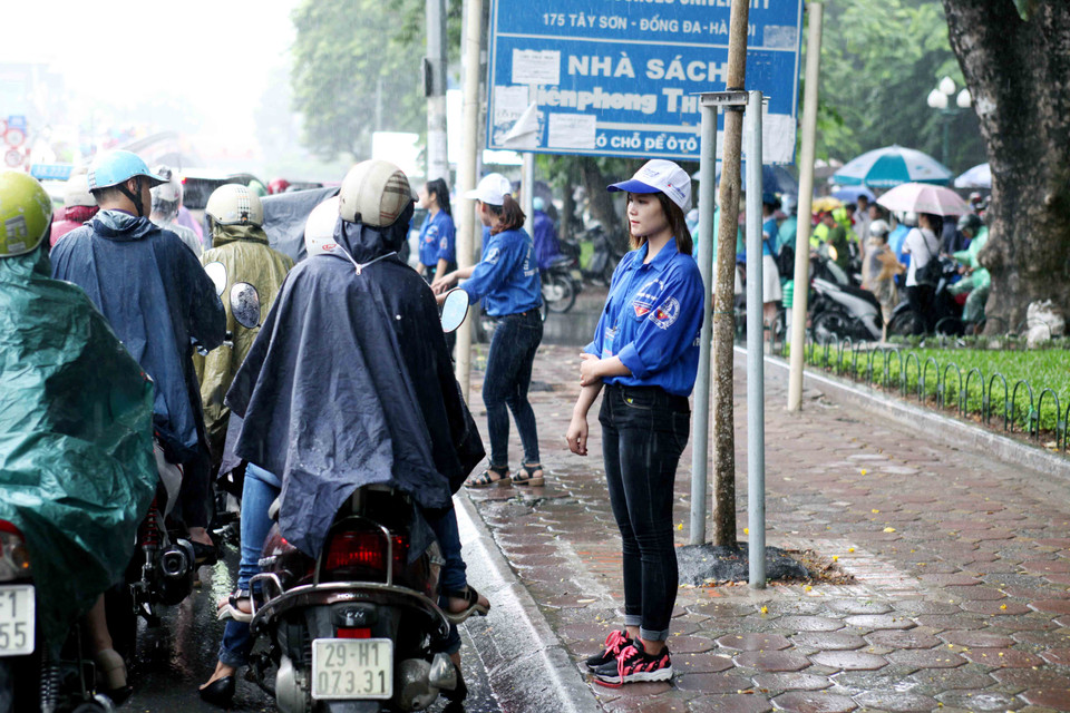 Trời mưa khá to nên cũng gây ra một số khó khăn đối với các thí sinh đến làm thủ tục. (Ảnh: Doãn Đức/Vietnam+)