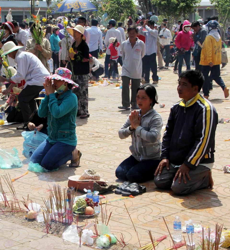 Do không còn chỗ trống nên nhiều người phải bày lễ vật, thắp hương và cầu nguyện từ xa dưới tượng Phật Bà Nam Hải tại khu Quán Âm Phật Đài, thành phố Bạc Liêu, tỉnh Bạc Liêu. (Ảnh: Thanh Liêm/TTXVN)
