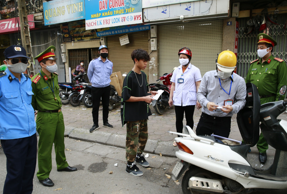 Tổ công tác của phường Đồng Nhân (quận Hai Bà Trưng, Hà Nội) xử phạt các trường hợp vi phạm không đeo khẩu trang ra đường. (Ảnh: Doãn Tấn/TTXVN)